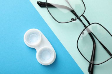 Renk arkaplanında kontak lensler ve gözlükler düz konum