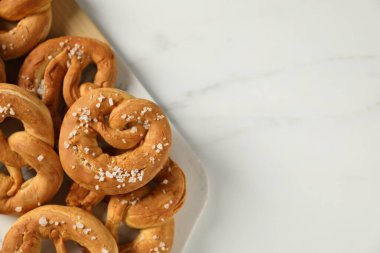 Beyaz mermer masada tuzlu krakerler, düz. Metin için boşluk