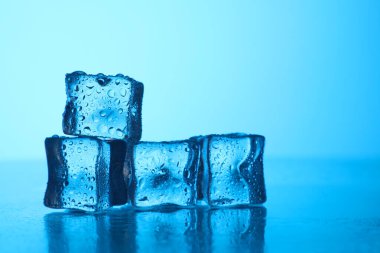 Açık mavi zemin üzerinde açık buz küpleri, yakın plan. Metin için boşluk