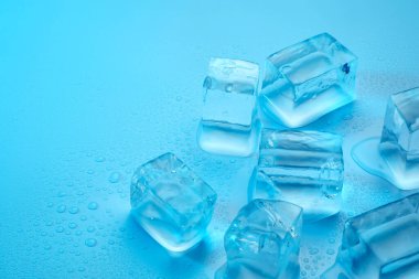Açık mavi zemin üzerinde açık buz küpleri, yakın plan. Metin için boşluk