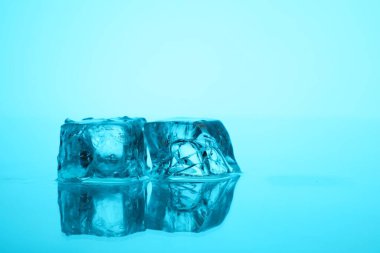 Açık mavi zemin üzerinde açık buz küpleri, yakın plan. Metin için boşluk