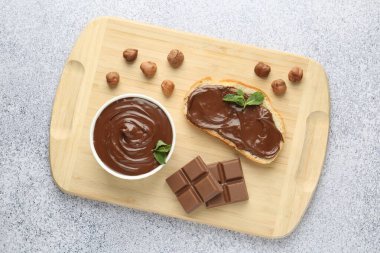 Lezzetli çikolata, tost, fındık ve nane. Gri desenli masa, üst manzara.