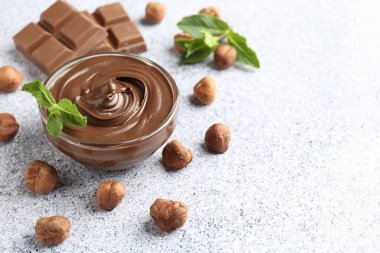 Lezzetli çikolata, naneli kase ve fındıklı gri desenli masa, yakın plan. Metin için boşluk