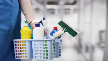 Ofisinde farklı temizlik malzemeleri ve ürünleri olan bir kadın, yakın plan. Metin için pankart tasarımı ve boşluk