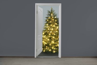 Kapının önünde şenlik ışıkları olan güzel bir Noel ağacı. Tatil sezonu