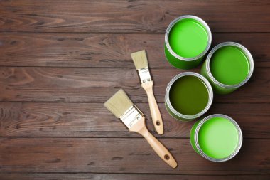 Yeşil tonlarda boyalar ve ahşap arka planda fırçalar, üst manzara. Metin için boşluk