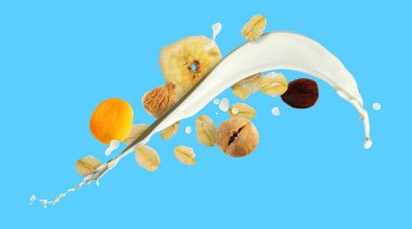 Süt sıçraması, yulaf ezmesi ve açık mavi arka planda kurutulmuş meyve. Pankart tasarımı