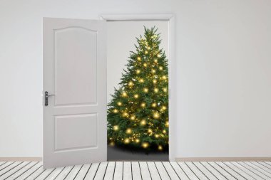 Kapının önünde şenlik ışıkları olan güzel bir Noel ağacı. Tatil sezonu