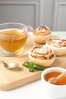 Nane, bal ve çay ile taze pişmiş elma gülleri beyaz masada, yakın plan.