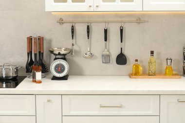 Retro mekanik mutfak ölçeği, beyaz mermer masa üzerindeki diğer mutfak aletleri ve baharatlar.