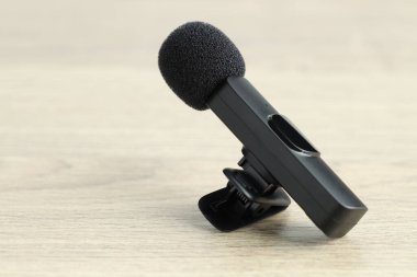 Lavalier mikrofonu ahşap masada, yakın plan. Ses ekipmanları