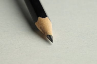 Hafif arkaplanda keskin bir grafit kalem, yakın plan.