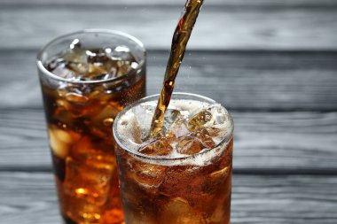 Gri ahşap masada ferahlatıcı kolayı cama boşalt.