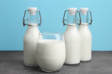 Açık mavi arka planda gri masada taze süt