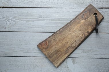 Gri ahşap masada bir tahta kesme tahtası, üst manzara. Metin için boşluk