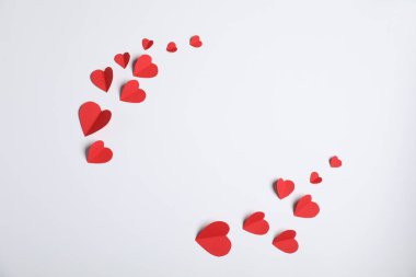 Açık gri arkaplanda bir sürü kağıt kalp, düz bir zemin. Metin için boşluk
