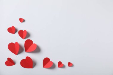 Açık gri arkaplanda bir sürü kağıt kalp, düz bir zemin. Metin için boşluk
