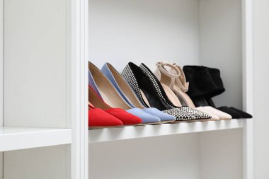 Ayakkabı deposu. İçerideki raflarda farklı yüksek topuklu ayakkabılar.