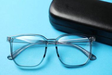 Açık mavi arka planda şık gözlüklü çanta, yakın plan