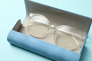 Açık mavi arka planda şık gözlüklü çanta, yakın plan