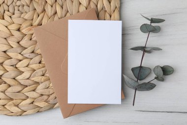 Boş tebrik kartı ve okaliptüs dalı hafif ahşap arka plan, düz uzanma