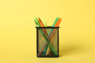 Sarı arkaplanda tükenmez kalemler, yakın plan.