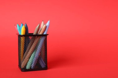 Kırmızı arka planda tükenmez kalemler, yakın plan. Metin için boşluk