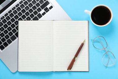 Kalem, açık defter, kahve, bardaklar ve dizüstü bilgisayar açık mavi arka plan, düz uzanma