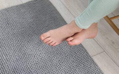 Evdeki yumuşak halının üstündeki kız, yakın plan. Metin için boşluk