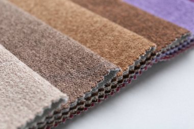 Beyaz arka planda farklı kumaş örnekleri, yakın plan. Metin için boşluk