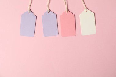 Pembe arka planda ipleri olan boş etiketler, düz yatış. Metin için boşluk