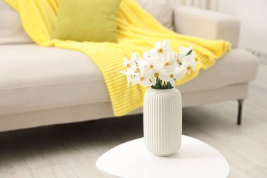 Evdeki beyaz masada vazodaki güzel nergisler, metin için yer.