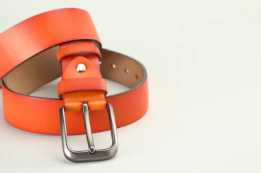 Beyaz arka planda turuncu deri kemer, yakın plan. Metin için boşluk