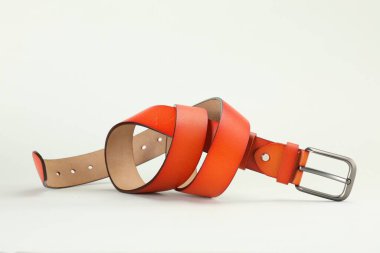 Beyaz arka planda bir turuncu deri kemer.