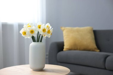 İçerideki ahşap masada vazodaki güzel nergisler, metin için yer.