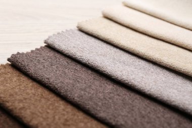 Tahta masadaki farklı kumaşlardan örnekler, yakın plan.