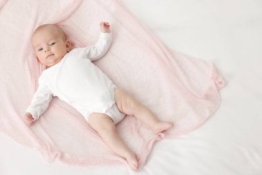 Evdeki yatakta uzanmış şirin küçük bebek, üst manzara. Metin için boşluk
