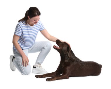 Mutlu kadın köpeğini beyaz arka planda eğitiyor.