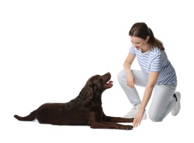 Mutlu kadın köpeğini beyaz arka planda eğitiyor.