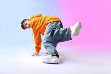 Renkli arka planda dans eden şık elbiseli çocuk.