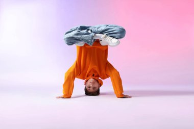 Renkli arka planda dans eden şık elbiseli çocuk.