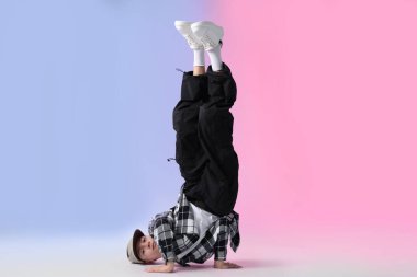 Renkli arka planda dans eden şık elbiseli çocuk.