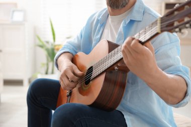 Evde gitar çalan adam, eline odaklan.