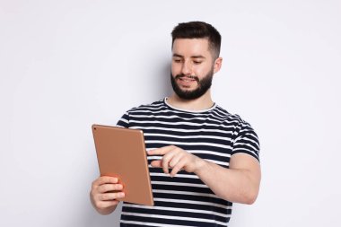 Yakışıklı adam beyaz zemin üzerine tablet kullanma