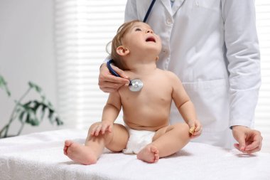 Pediyatrist klinikte küçük şirin bir bebeği muayene ediyor.