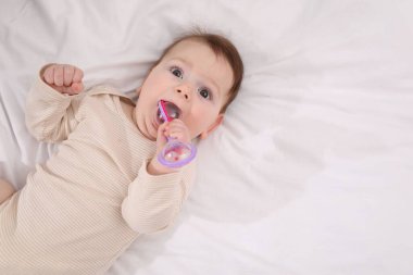 Evdeki yatağında çıngıraklı oyuncağı olan sevimli bir bebek. Metin için boşluk