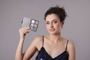 Gri arka planda göz falı olan gülümseyen kadın.