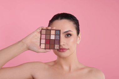 Pembe arka planda göz farı olan bir kadın.