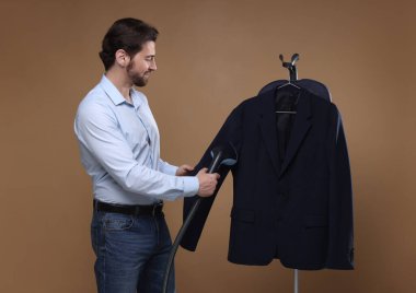 Kahverengi arka planda buharlı adam ceketi.