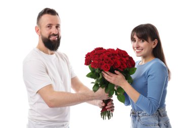 Adam beyaz arka planda sevgilisine kırmızı gül buketi sunuyor.
